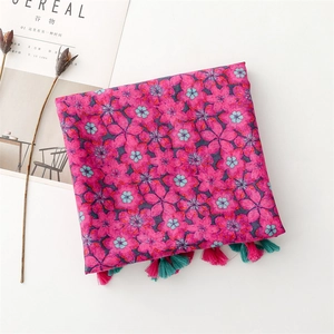 Detail of rose pink floral scarf with blue cherry blossoms and bicolor fringe tassels