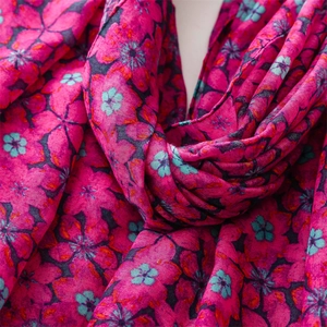 Close-up of rose pink floral cotton scarf showing delicate fabric texture and stitched edges