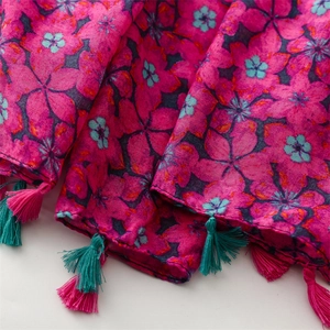 Detail of floral silk scarf with pink tassels and vibrant ethnic flower print pattern