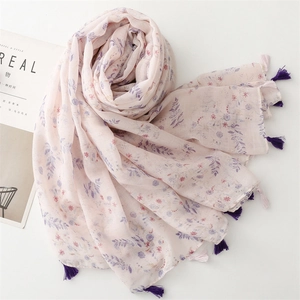 Dettaglio ravvicinato della sciarpa floreale rosa chiaro con nappe viola su sfondo bianco