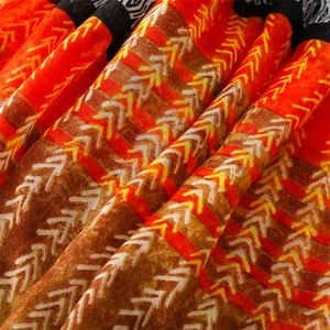 Detail of ethnic geometric arrow print fabric with warm orange and brown textured weave