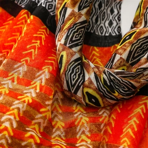Macro shot of ethnic geometric patterns in orange and brown on lightweight cotton scarf