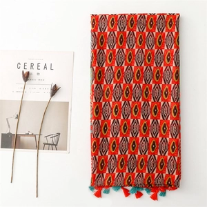 Detail of geometric rhombus pattern shawl with fringe tassels and colorful ethnic print