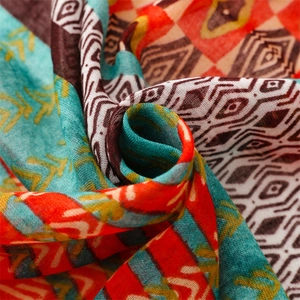 Close-up of bohemian silk scarf fabric with geometric diamond patterns and soft texture