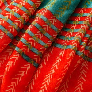 Close-up of red and teal ethnic scarf with yellow arrow geometry pattern and soft texture