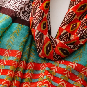 Macro detail of geometric print scarf showing linen texture and vibrant ethnic patterns