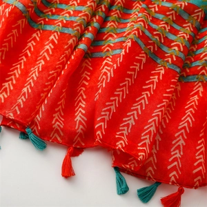 Detailed texture of orange tribal scarf with geometric patterns and fringe edges