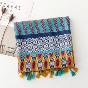 Detailed view of ethnic geometric print scarf with turquoise and yellow fringe tassels