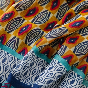 Macro detail of breathable ethnic geometric print fabric in blue, red and yellow