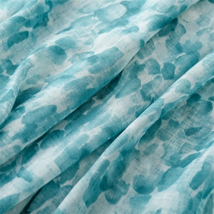 Detailed macro texture of a lightweight lake blue and white watercolor linen scarf