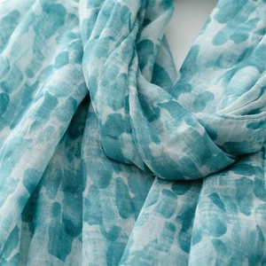 Detailed close-up of teal and white tie-dye scarf showing soft linen texture and weaving