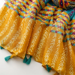 Close-up of ethnic geometric scarf with wheat ear patterns and turquoise tassels