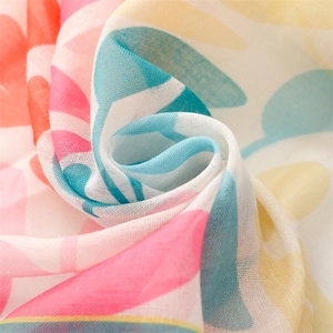 Détail macro du tissu léger d'écharpe florale montrant des motifs de feuilles colorés