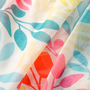 Détail macro d'une écharpe fleurie rose au toucher lin avec motifs botaniques fins