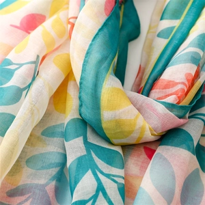 Détail du motif de feuilles abstraites rose et bleu sarcelle sur le tissu du foulard