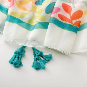 Détail d'écharpe à imprimé floral tropical avec pompons bleus et texture légère