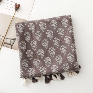 Macro view of geometric floral print scarf with elegant two-tone tassel edge detail