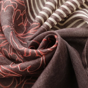 Macro detail of cotton-linen feel scarf with red floral outlines and stripe patterns