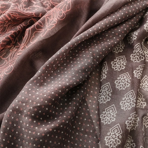 Detail of bohemian scarf showing ethnic floral and geometric patterns on soft linen fabric