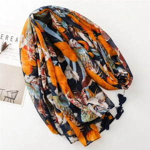 Detailed view of floral pattern scarf with navy tassels on white background
