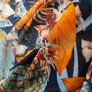 Macro detail of tropical pineapple print on navy blue summer scarf with premium fabric texture