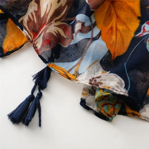 Detail of vibrant pineapple leaf print on thin summer scarf with navy tassel fringe