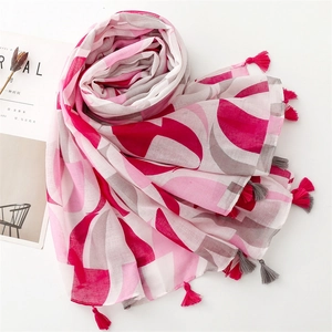 Detail of color-block scarf with pink and grey tassels on a clean white background