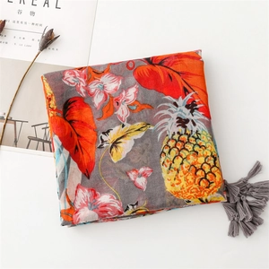 Detail of grey scarf featuring tropical pineapple prints and tassel fringe on edges