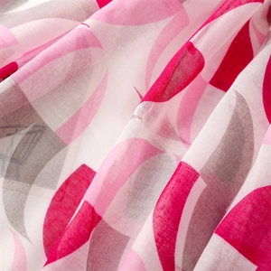 Detail view of lightweight floral chiffon fabric with pink and grey circular patterns