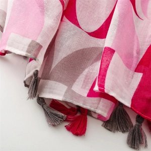 Close-up of geometric print cotton linen scarf featuring colorful tassel fringe edges