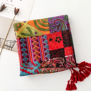 Detailed shot of bohemian scarf with colorful paisley prints and vibrant red tassels