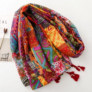 Detail of red Bohemian scarf with paisley patterns, floral prints and fringe tassels