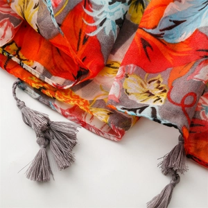 Detailed view of colorful tropical floral print scarf featuring gray fringe and breathable fabric