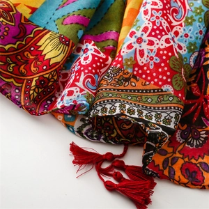 Close-up of bohemian scarf with vibrant ethnic print and red fringe tassel details