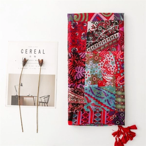 Detail of red Bohemian shawl with mixed floral prints and elegant tassel fringe trim