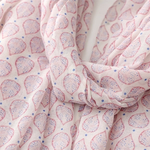 Detail of soft lightweight scarf with pink leaf patterns and blue dots on white fabric