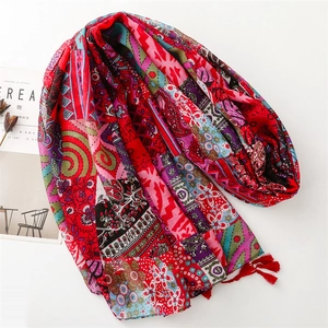 Detail of red Bohemian scarf with floral patchwork patterns and delicate tassels