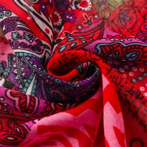 Close-up detail of red Bohemian cotton-linen scarf with ethnic paisley print and texture
