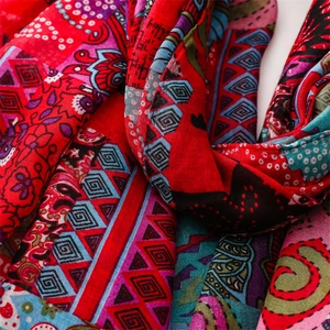 Close-up of bohemian red linen scarf with colorful ethnic geometric patterns and textures