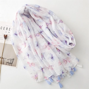 Detail of cotton linen scarf featuring butterfly print, fringe edges, and silver threads