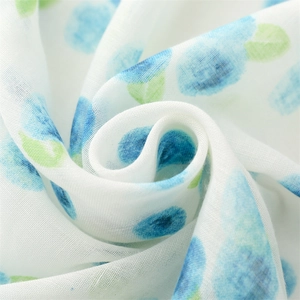 Macro view of lightweight fabric showing blue and green watercolor polka dot patterns