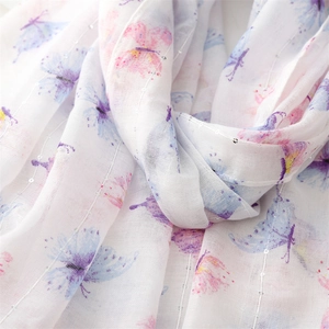 Macro detail of breathable cotton linen scarf with butterfly prints and silver sequins