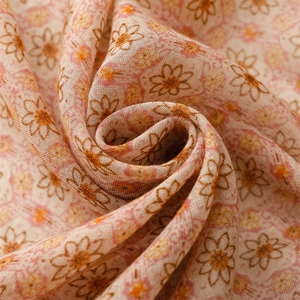 Macro view showing soft texture and floral print of light brown cotton scarf fabric
