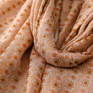 Detail of soft pink floral scarf with small daisy print and light breathable fabric