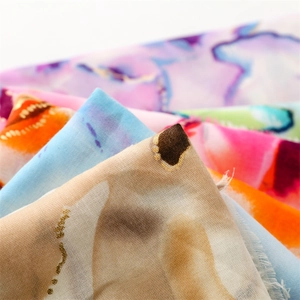 Macro shot of abstract watercolor printed scarf fabric with frayed fringe edges