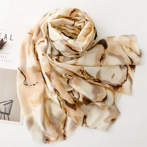 Detailed texture of cotton linen scarf with gold marble pattern and raw fringed edges