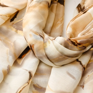 Detail showing gold leaf floral pattern and abstract ink textures on cotton-linen scarf