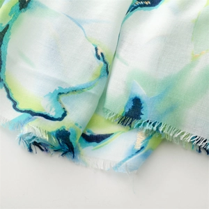Close-up of cotton linen scarf with watercolor floral patterns and frayed edge details