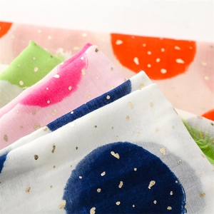 Detail of cotton linen scarf featuring gold foil polka dots and soft fringed edges