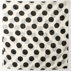 Detailed view of white cotton-linen scarf with black polka dots and frayed edge texture